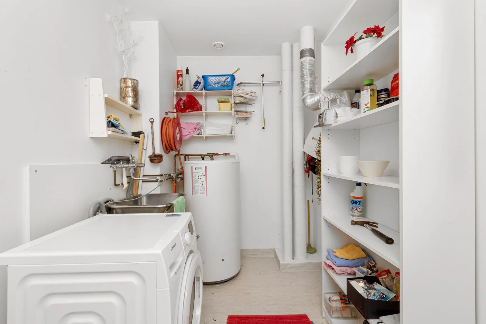 Clean home laundry room with washing machine and water heater