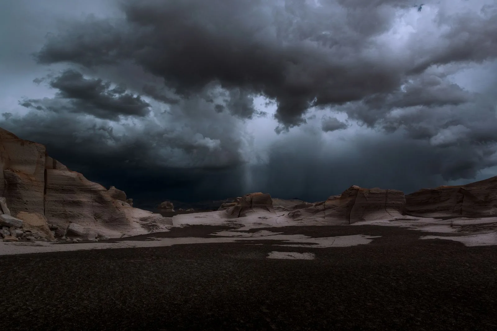 Dark storm clouds gathering over a dramatic desert landscape