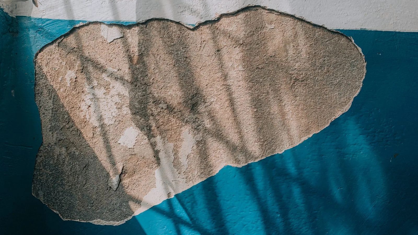 Interior wall with peeling paint and exposed plaster from water damage